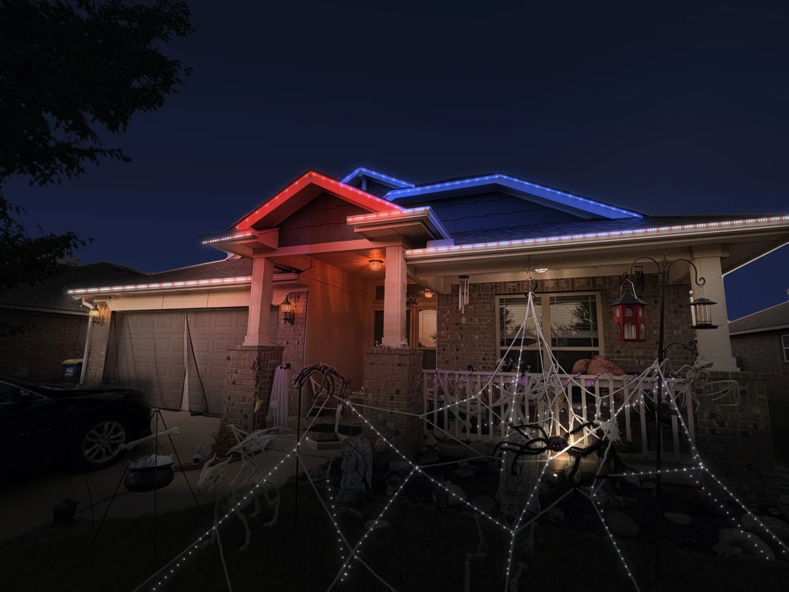 Mockup of a brick home at night with its roofline lit in red, white and blue