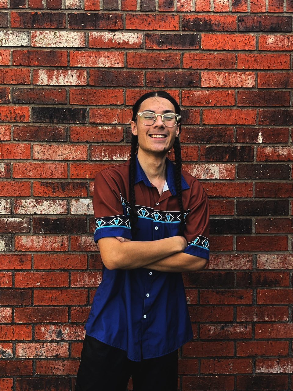 Sol Zendejas-Smith, owner of Curbsight Lighting, standing in front of a brick wall in Yukon